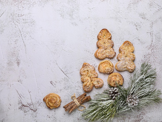 Photo biscuits de noël à partir de pâte feuilletée sous forme d'arbres de noël sur fond clair.