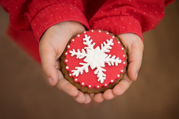 Biscuits de Noël rouges avec flocon de neige main dans la main