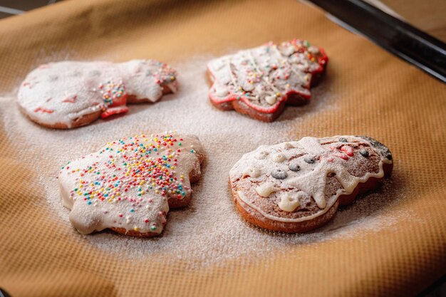 Photo des biscuits de noël saupoudrés de sucre glacé sur une feuille de cuisson