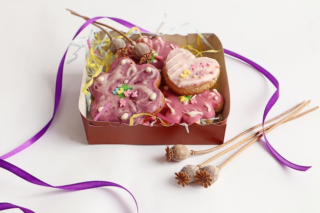 Biscuits de pain d'épice dans le paquet branches de pavot ruban lumineux sur un fond blanc place pour le texte