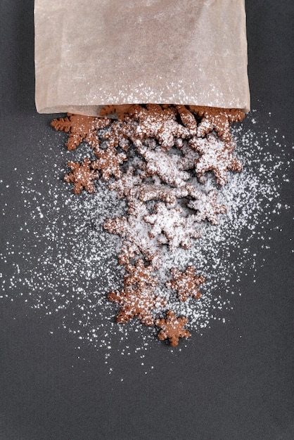 Biscuits de pain d'épice en forme d'étoile saupoudrés de sucre en poudre Vue de dessus sur fond gris Cadre vertical