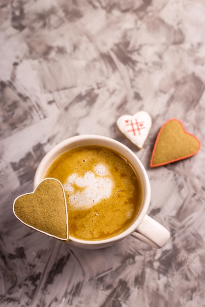 Biscuits de pain d&#39;épice maison en forme de coeur sur une tasse de cappuccino