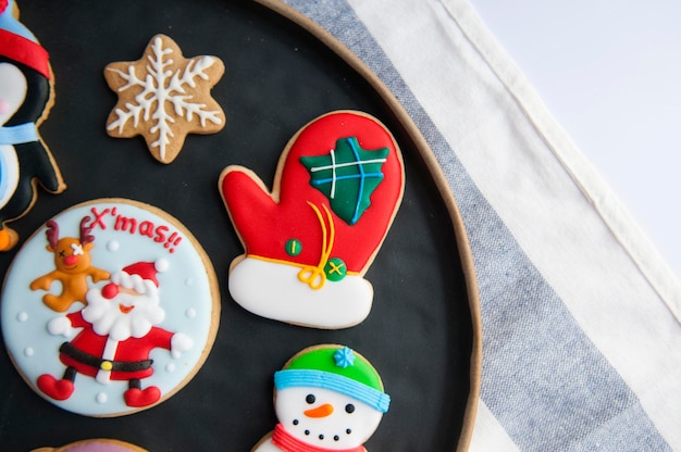 Des biscuits de pain d'épice multicolores pendant Noël dans une assiette
