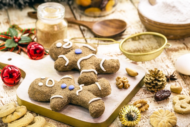 Biscuits de pain d'épice de Noël, homme en pain d'épice fait maison, cuit au four, avec des fruits et des noix autour