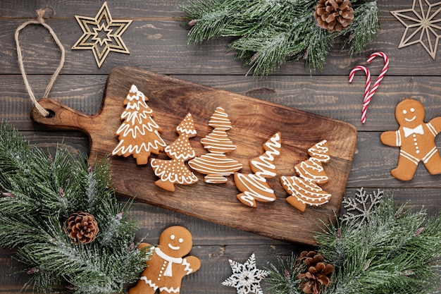 Biscuits de pain d'épice savoureux et décor de Noël sur fond en bois.