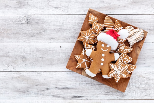 Biscuits de pain d'épice savoureux et décor de Noël sur fond en bois.