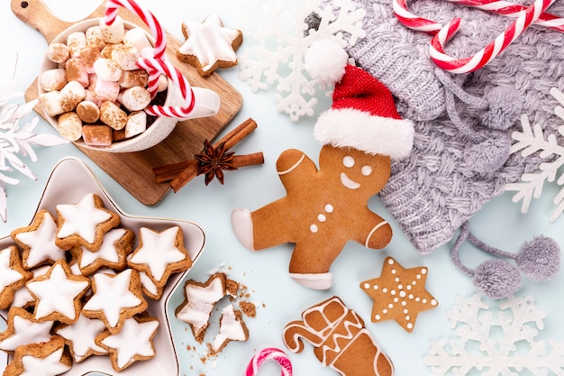 Biscuits de pain d'épice savoureux et décor de Noël sur fond pastel.