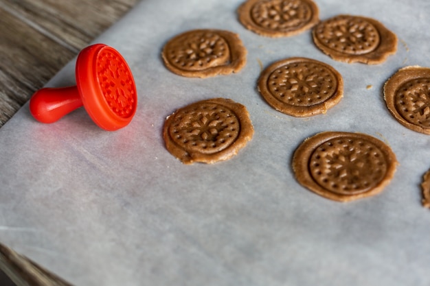 Biscuits de pain d&#39;épices crus de la pâte sur le parchemin.