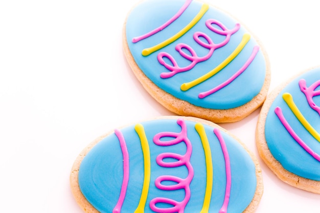 Biscuits de Pâques en forme d'oeuf décorés de glaçage bleu.