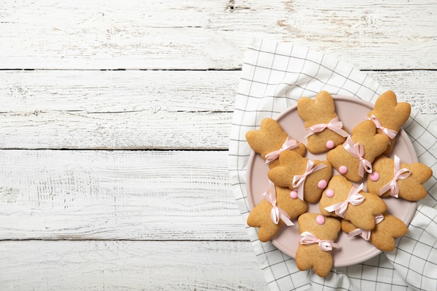 Biscuits de Pâques sur une plaque sur un fond en bois. Lapins de Pâques. Place pour le texte.