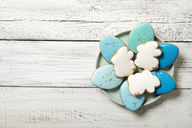 Biscuits de Pâques sur une plaque sur un fond en bois. Œufs de Pâques. Lapins de Pâques. Place pour le texte.