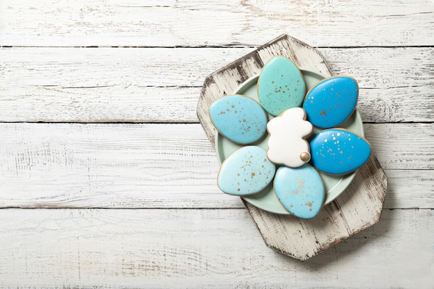 Biscuits de Pâques sur une plaque sur un fond en bois. Œufs de Pâques. Lapins de Pâques. Place pour le texte.