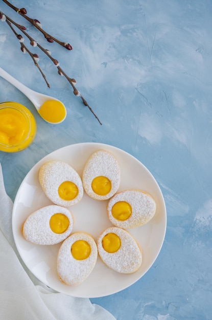 Biscuits de Pâques sous forme d'oeuf de Pâques avec du sucre en poudre et de la crème au citron Fond de Pâques