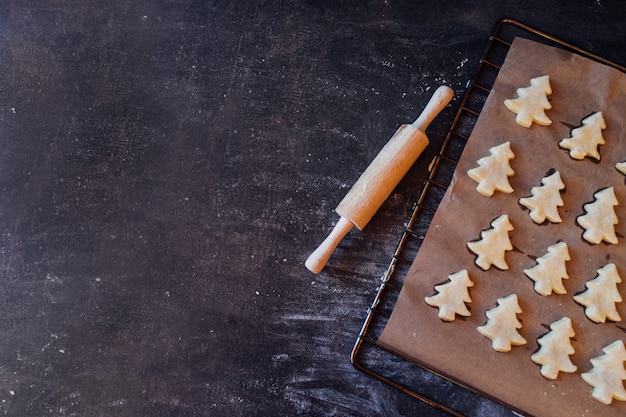 Biscuits de pâte crue en forme d&#39;arbre de Noël prêts à cuire