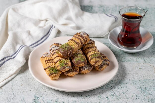 Biscuits à la pistache au chocolat et à la noix de coco sur fond gris Assortiment de biscuits de boulangerie Biscuits avec une tasse de thé