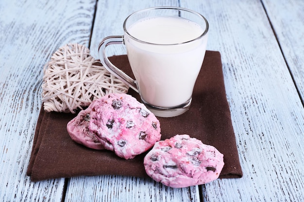 Biscuits roses et tasse de lait sur le gros plan de table