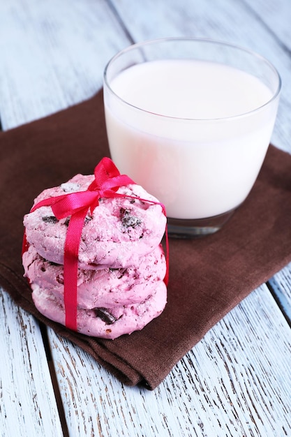 Biscuits roses et verre de lait sur le gros plan de table