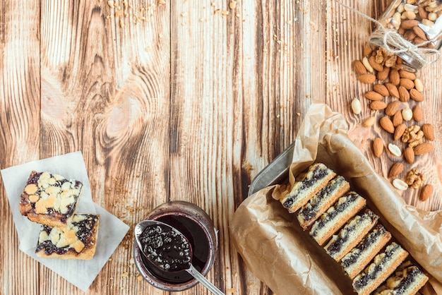 Biscuits sablés à la confiture de bleuets sur du papier sulfurisé sur fond de bois.