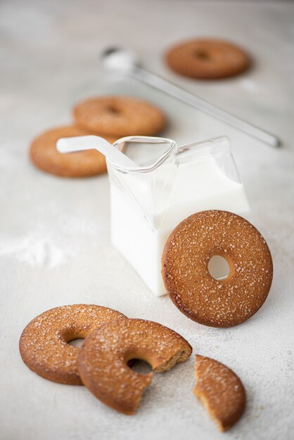 Biscuits sablés ronds avec du sucre et du lait froid sur un tableau blanc