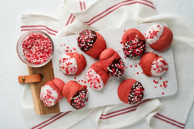 Biscuits de la Saint-Valentin Biscuits sablés avec glaçage chocolat blanc et noir et pépites de coeur sur plaque sur fond blanc Fête des mères Fête de la femme Fêtes douces cuisson Vue de dessus