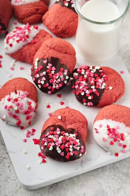 Biscuits de la Saint-Valentin Biscuits sablés avec glaçage chocolat blanc et noir et pépites de coeur sur plaque sur fond blanc Fête des mères Fête de la femme Fêtes douces cuisson Vue de dessus