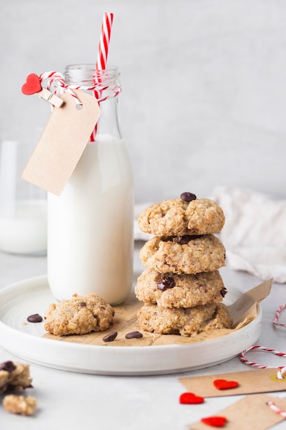 Biscuits de la Saint-Valentin avec du chocolat sur une plaque de lait bouteille de coeurs sur un tableau blanc