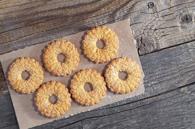 Biscuits saupoudrés de sucre sur une vieille surface en bois, vue de dessus