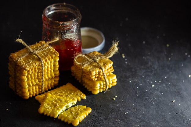 Les biscuits sont attachés avec une corde de chanvre et une bouteille de confiture de fraises sur la table