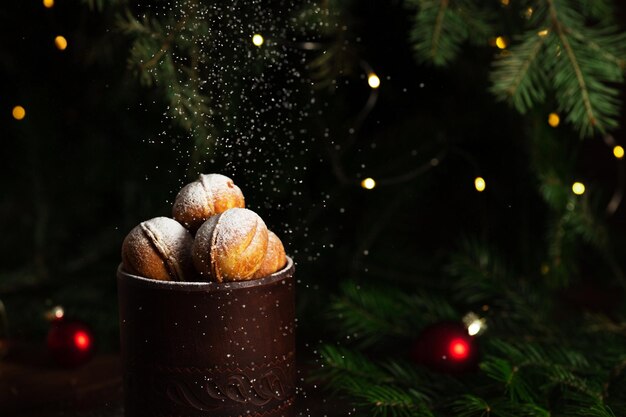 Biscuits sous forme de noix dans un verre d'argile. Du sucre en poudre est versé sur le dessus.