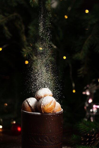 Biscuits sous forme de noix dans un verre d'argile. Du sucre en poudre est versé sur le dessus.