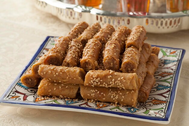 Des biscuits traditionnels marocains de fête avec des graines de sésame et du thé à la menthe