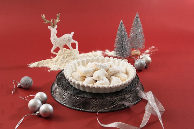 Biscuits à la vanille fraîche Vanillekipferl avec du sucre en poudre pour Noël avec décoration rouge