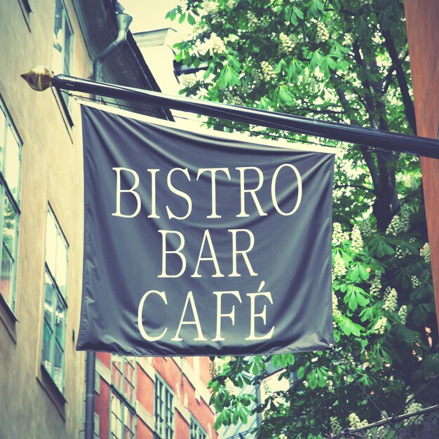 Photo bistro bar cafe signe sur le drapeau dans la rue. image filtrée de style rétro