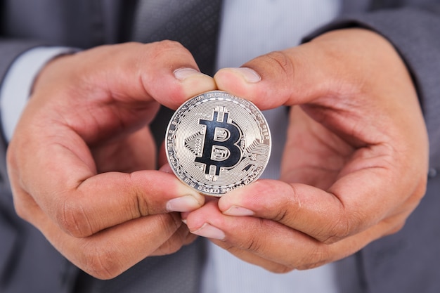 Photo bitcoin d'argent dans la main de l'homme d'affaires