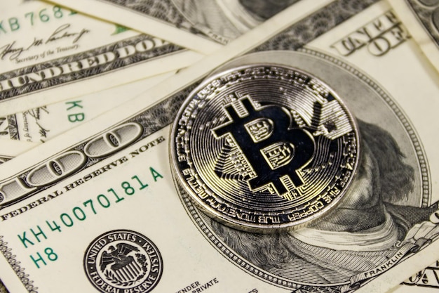 Bitcoin argent sur fond de billets de cent dollars