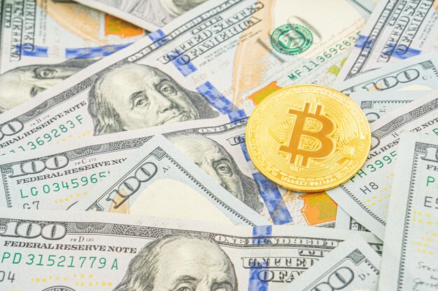 Bitcoin sur les billets de cent dollars Monnaie symbolique d'or Bitcoin sur les banknotes de cent dollars Cryptocurrency sur les bilets de dollar américain Méthode de paiement moderne numérique Échange de bitcoins en espèces