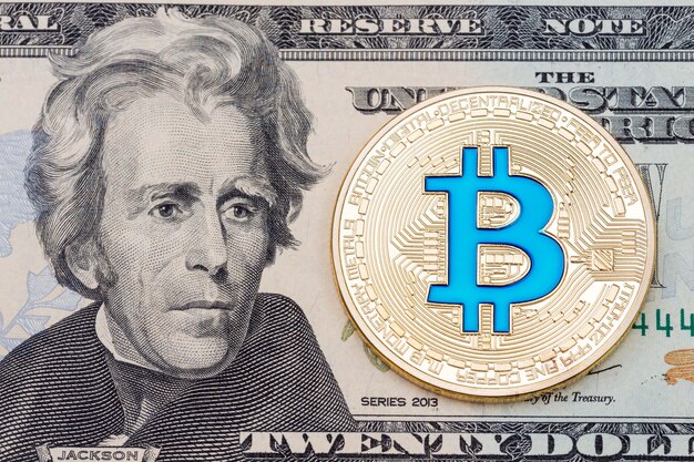 Bitcoin bleu crypto-monnaie doré sur fond de billet de vingt dollars. Photo haute résolution.