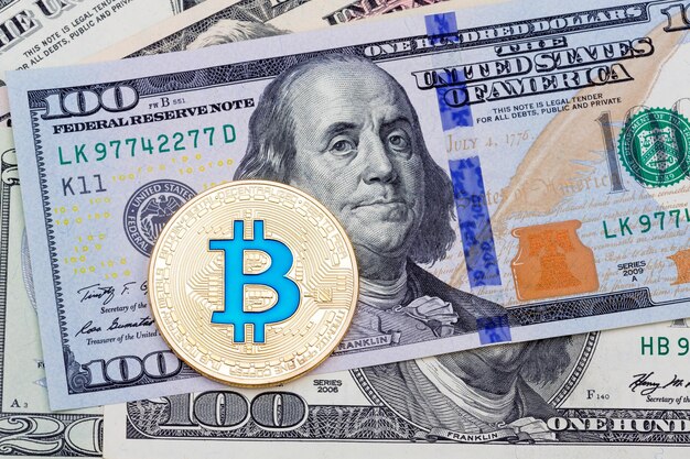 Bitcoin bleu jaune sur fond de cent billets. Photo haute résolution.