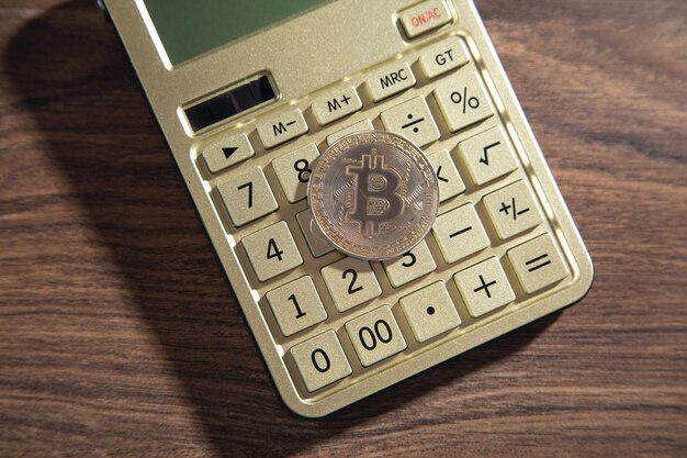 Bitcoin et calculatrice sur la table en bois