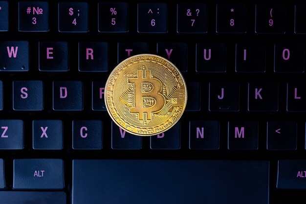 Bitcoin sur le clavier de l'ordinateur en surface, symbole de la monnaie virtuelle électronique et concept de crypto-monnaie minière