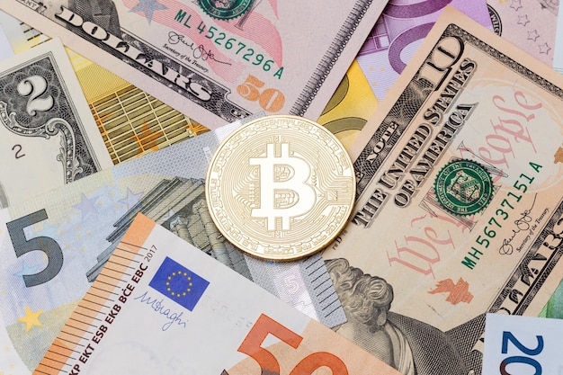 Bitcoin cruptocurrency doré sur fond dollar et euro