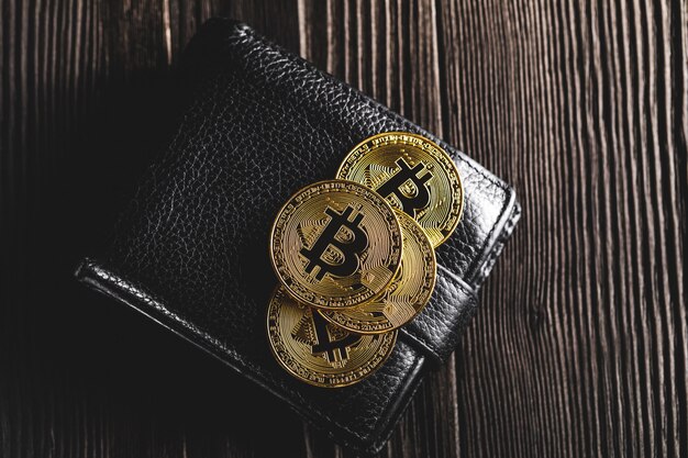 Bitcoin avec dollar sur sac à main isolé noir