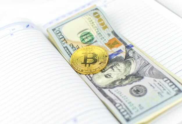 Bitcoin et dollars se trouvant sur le journal