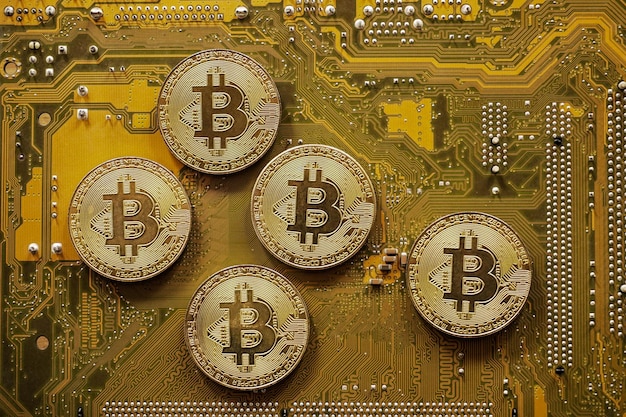 Photo bitcoin doré sur la carte mère de l'ordinateur, concept d'exploitation minière bitcoin