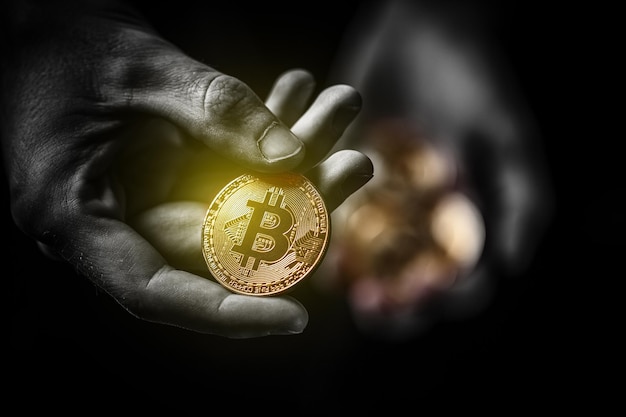 Bitcoin doré dans la main d'un homme