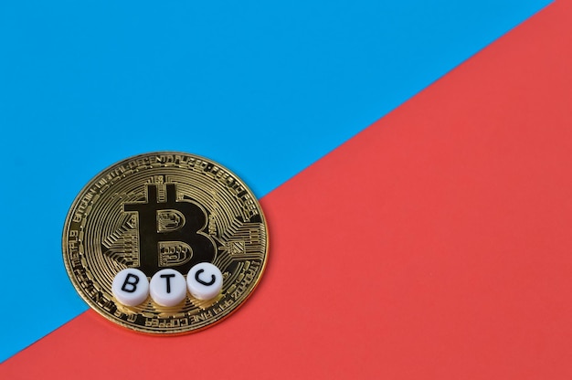 Bitcoin doré isolé sur fond bleu et rouge