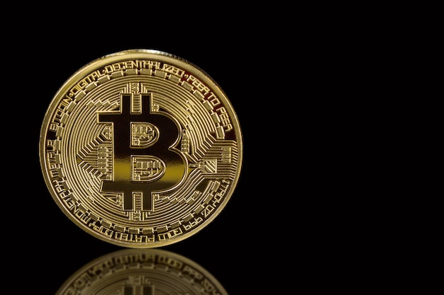 Bitcoin doré isolé sur fond noir avec reflet