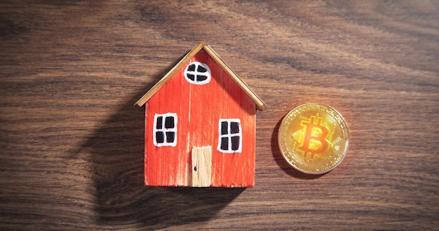 Bitcoin et modèle de maison sur la table en bois