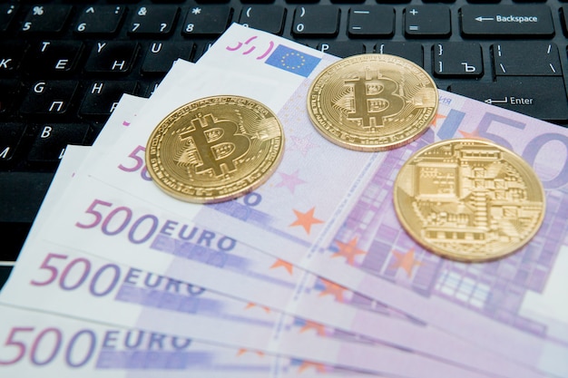 Bitcoin d'or sur des billets en euros. Image symbolique de la monnaie virtuelle.