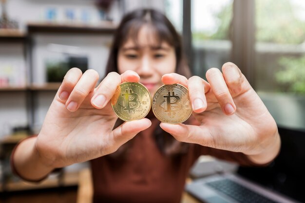 Bitcoin d&#39;or (crypto-monnaie) dans la main de femme d&#39;affaires